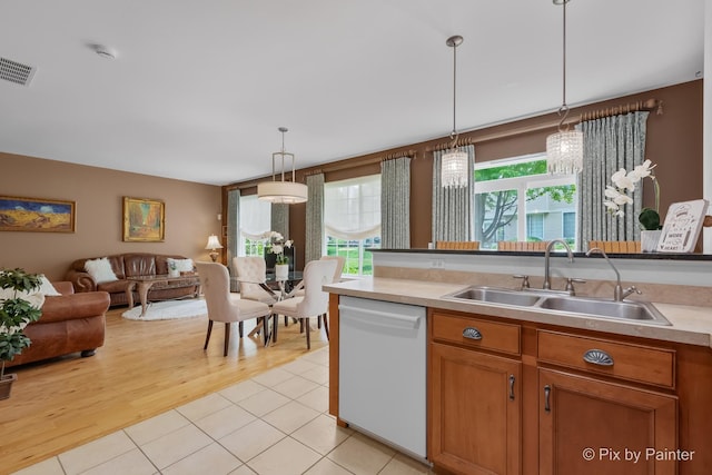5611 Wildspring Dr, Lake In The Hills, IL 60156 - kitchen with dishwasher, a sink, open floor plan, decorative light fixtures, and light countertops