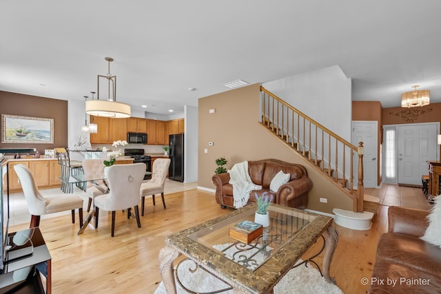5611 Wildspring Dr, Lake In The Hills, IL 60156 - living room with a chandelier, stairs, baseboards, light wood-style flooring, and recessed lighting