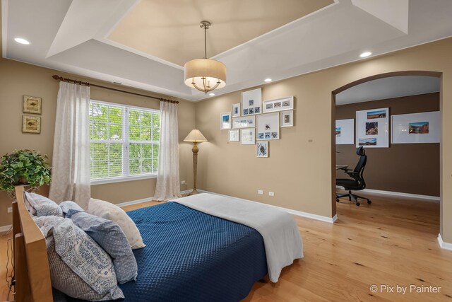 5611 Wildspring Dr, Lake In The Hills, IL 60156 - bedroom with light wood-style flooring, baseboards, arched walkways, a raised ceiling, and recessed lighting