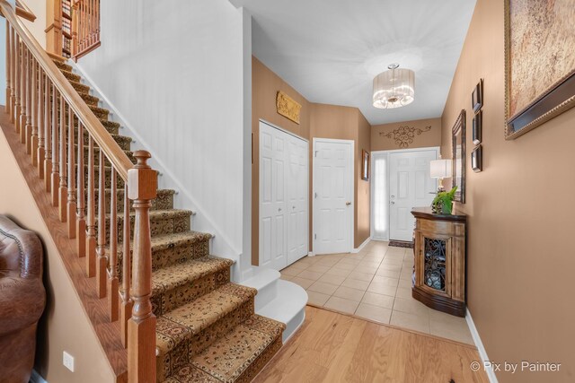 5611 Wildspring Dr, Lake In The Hills, IL 60156 - entryway with stairs, a chandelier, baseboards, and light tile patterned floors