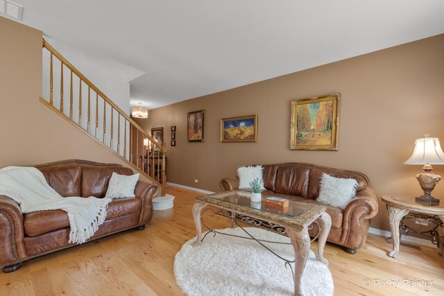 5611 Wildspring Dr, Lake In The Hills, IL 60156 - living area featuring stairs, wood finished floors, baseboards, and a chandelier