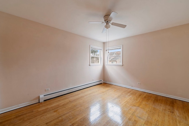 6248 W Montrose Ave Unit 1R, Chicago, IL 60634 - empty room featuring a baseboard radiator, ceiling fan, wood finished floors, and baseboards