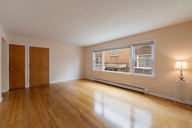 6248 W Montrose Ave Unit 1R, Chicago, IL 60634 - empty room with baseboard heating, wood finished floors, and baseboards