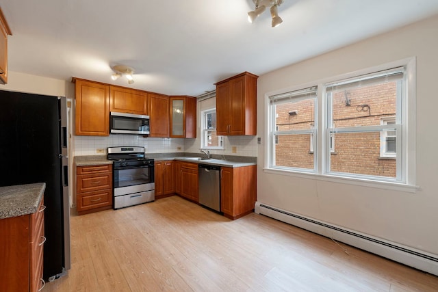6248 W Montrose Ave Unit 1R, Chicago, IL 60634 - kitchen featuring stainless steel appliances, a baseboard radiator, brown cabinetry, and light wood finished floors