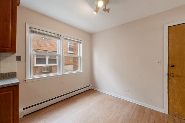 6248 W Montrose Ave Unit 1R, Chicago, IL 60634 - spare room with a baseboard radiator, light wood-style flooring, and baseboards