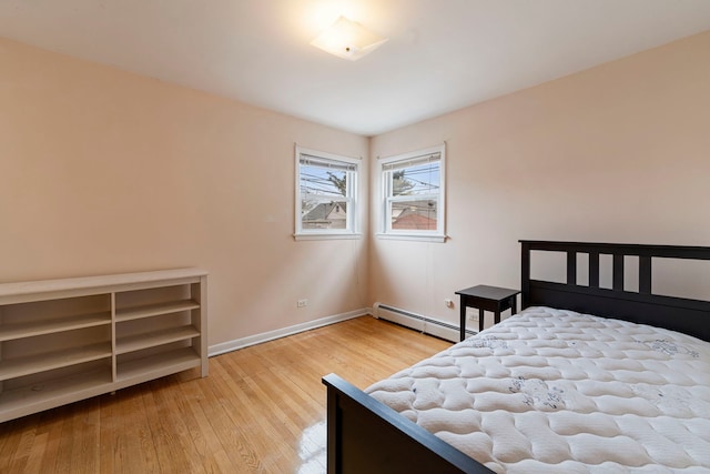 6248 W Montrose Ave Unit 1R, Chicago, IL 60634 - bedroom with a baseboard heating unit, baseboards, and wood finished floors