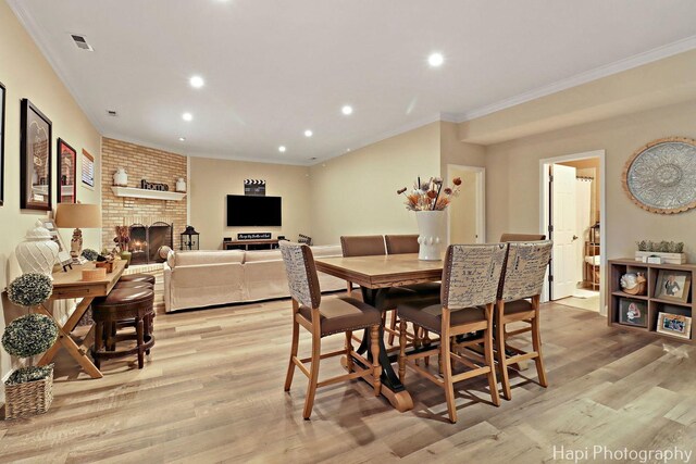 3334 N Odell Ave, Chicago, IL 60634 - dining room featuring crown molding, light wood finished floors, recessed lighting, and a fireplace