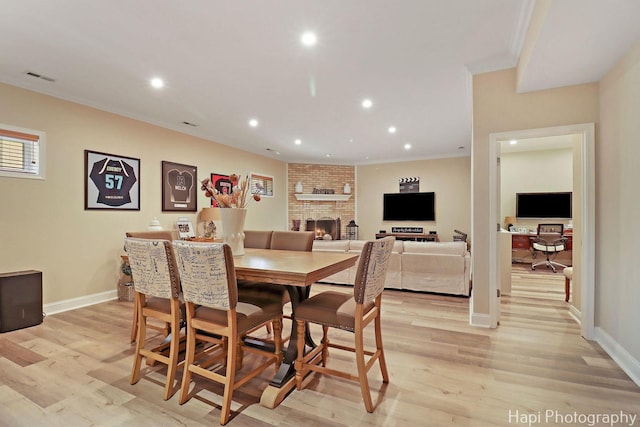 3334 N Odell Ave, Chicago, IL 60634 - dining room featuring light wood finished floors, recessed lighting, baseboards, a brick fireplace, and ornamental molding