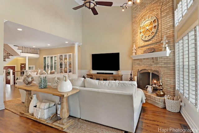 3334 N Odell Ave, Chicago, IL 60634 - living room featuring a towering ceiling, a ceiling fan, wood finished floors, a fireplace, and wainscoting