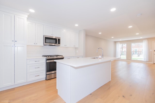 1537 N Clybourn Ave Unit D, Chicago, IL 60610 - kitchen with stainless steel appliances, a sink, a center island with sink, light countertops, and recessed lighting