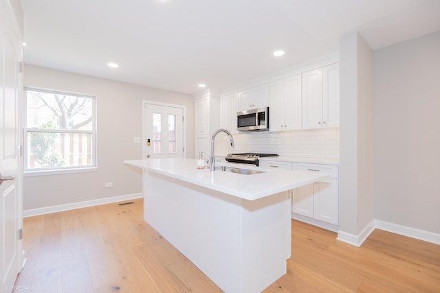 1537 N Clybourn Ave Unit D, Chicago, IL 60610 - kitchen featuring appliances with stainless steel finishes, light wood-style floors, white cabinets, and recessed lighting