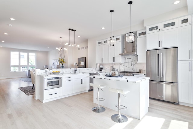 3450 N Central Ave, Chicago, IL 60634 - kitchen with stainless steel appliances, wall chimney exhaust hood, light wood-type flooring, a peninsula, and backsplash