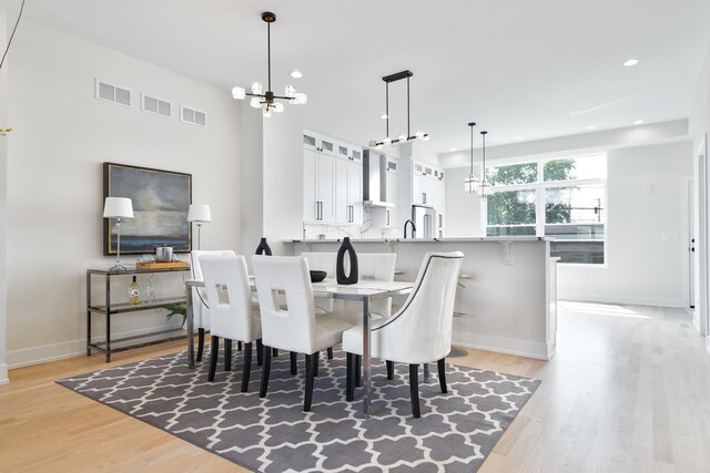 3450 N Central Ave, Chicago, IL 60634 - dining space featuring a chandelier, light wood-style flooring, recessed lighting, and baseboards