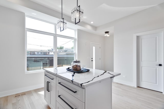 3450 N Central Ave, Chicago, IL 60634 - kitchen with a chandelier, light wood finished floors, light stone counters, pendant lighting, and white cabinetry