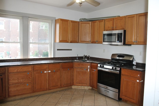 2102 Gunderson Ave, Berwyn, IL 60402 - kitchen featuring stainless steel appliances, brown cabinets, a ceiling fan, light tile patterned flooring, and dark stone countertops