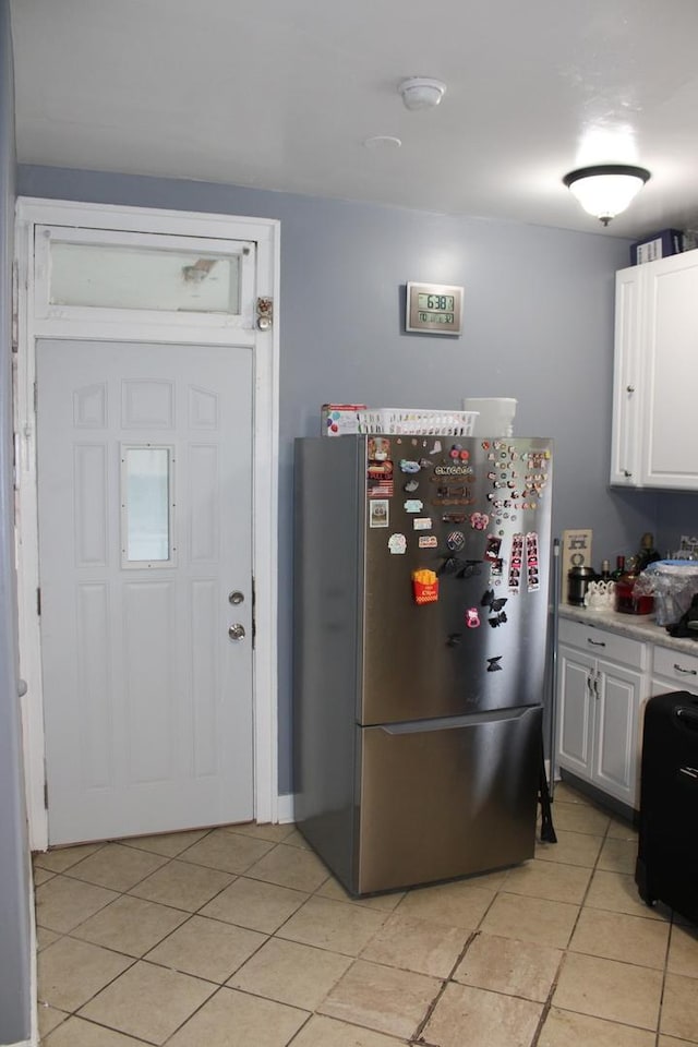 2102 Gunderson Ave, Berwyn, IL 60402 - kitchen featuring freestanding refrigerator, light tile patterned floors, white cabinets, and light countertops