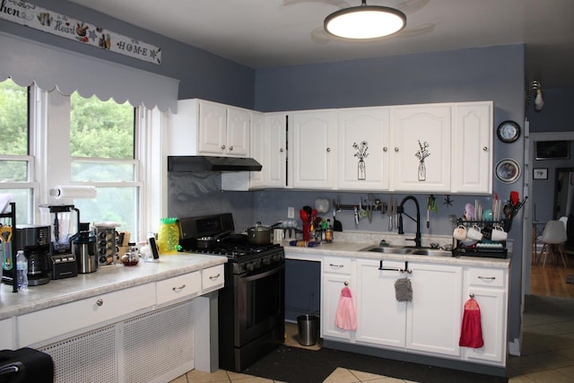 2102 Gunderson Ave, Berwyn, IL 60402 - kitchen featuring gas range, under cabinet range hood, light tile patterned floors, and white cabinetry