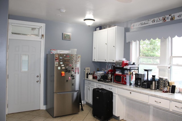 2102 Gunderson Ave, Berwyn, IL 60402 - kitchen featuring freestanding refrigerator, light tile patterned floors, light countertops, and white cabinetry