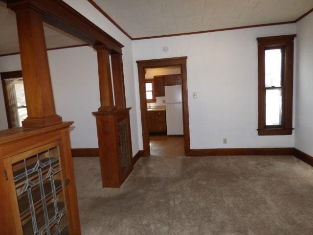 516 Spring St, Galena, IL 61036 - carpeted spare room featuring crown molding, decorative columns, and baseboards