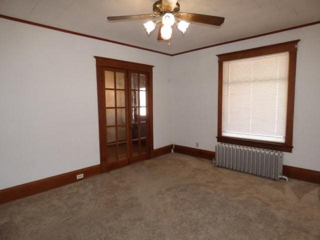 516 Spring St, Galena, IL 61036 - carpeted spare room featuring radiator heating unit, baseboards, ornamental molding, ceiling fan, and french doors