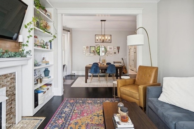 1466 W Warner Ave Unit 2W, Chicago, IL 60613 - living room featuring a chandelier, dark wood-style floors, a fireplace, crown molding, and baseboards