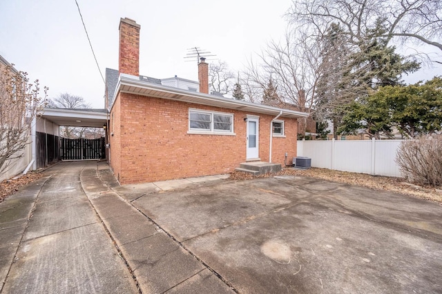 5651 N Osceola Ave, Chicago, IL 60631 - rear view of house with brick siding, a chimney, concrete driveway, and cooling unit