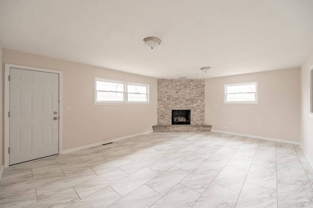 5651 N Osceola Ave, Chicago, IL 60631 - unfurnished living room featuring a stone fireplace, light marble finish flooring, and baseboards