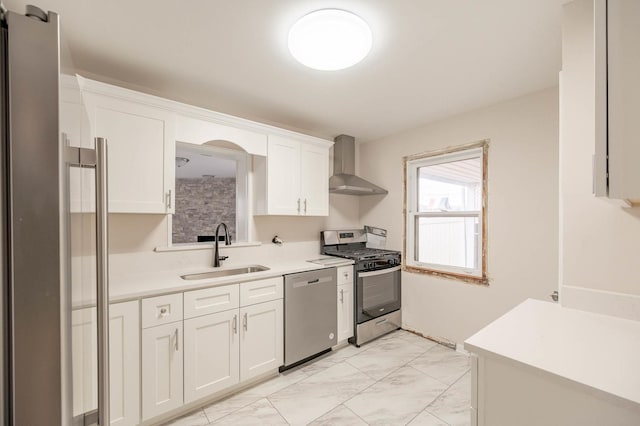 5651 N Osceola Ave, Chicago, IL 60631 - kitchen featuring appliances with stainless steel finishes, wall chimney range hood, a sink, light marble finish flooring, and white cabinetry