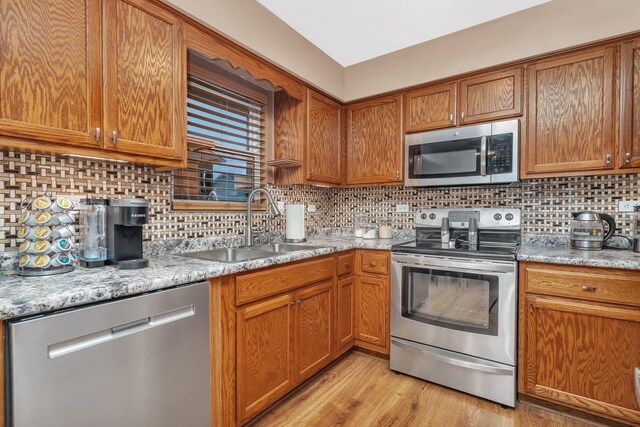 2111 Hastings Dr, Plainfield, IL 60586 - kitchen featuring stainless steel appliances, a sink, brown cabinets, and tasteful backsplash
