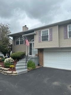 7612 W Saint Francis Rd Unit 7612, Frankfort, IL 60423 - raised ranch featuring a garage, asphalt driveway, and a chimney