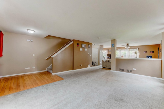 1715 Ivy Ln, Montgomery, IL 60538 - unfurnished living room featuring baseboards, carpet floors, stairs, and ceiling fan