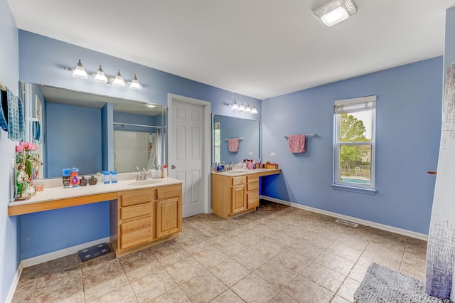1715 Ivy Ln, Montgomery, IL 60538 - bathroom featuring a shower with shower curtain, two vanities, tile patterned floors, and baseboards
