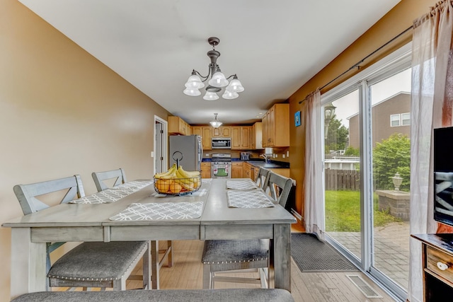 1715 Ivy Ln, Montgomery, IL 60538 - dining room featuring a chandelier and light wood-style flooring