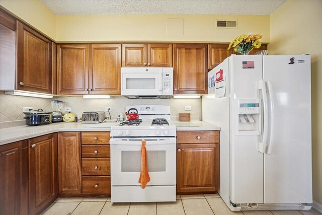 770 Pearson St Unit 604, Des Plaines, IL 60016 - kitchen with white appliances, light countertops, backsplash, and a textured ceiling