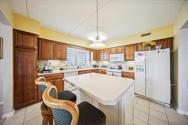 770 Pearson St Unit 604, Des Plaines, IL 60016 - kitchen featuring white appliances, light countertops, light tile patterned floors, a kitchen island, and hanging light fixtures