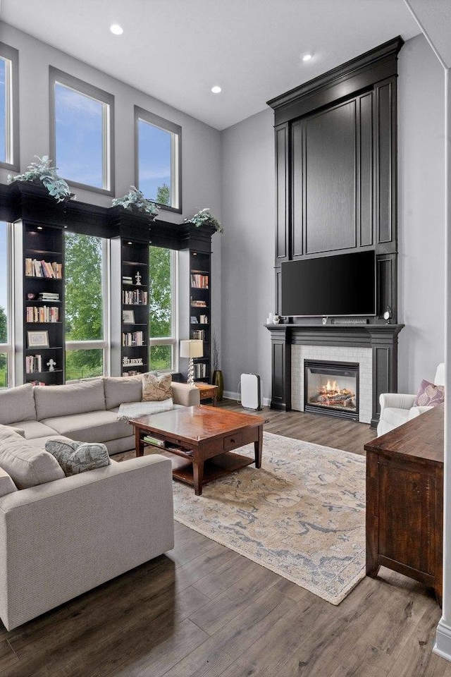 4 Emerald Crest Ct, Bloomington, IL 61705 - living area with wood finished floors, recessed lighting, a glass covered fireplace, and a high ceiling