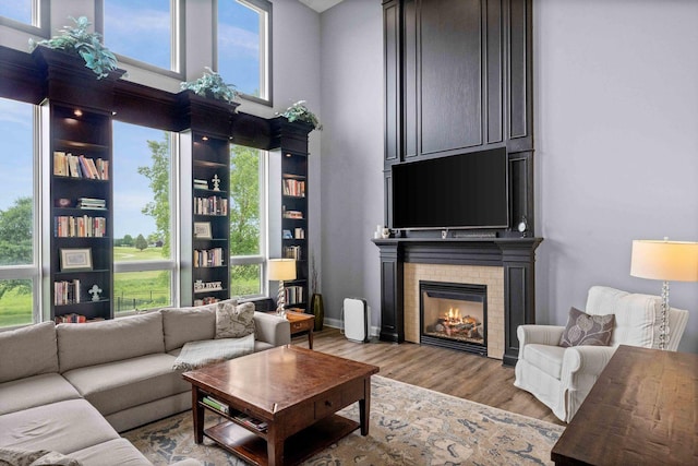 4 Emerald Crest Ct, Bloomington, IL 61705 - living room featuring a high ceiling, wood finished floors, a glass covered fireplace, and healthy amount of natural light