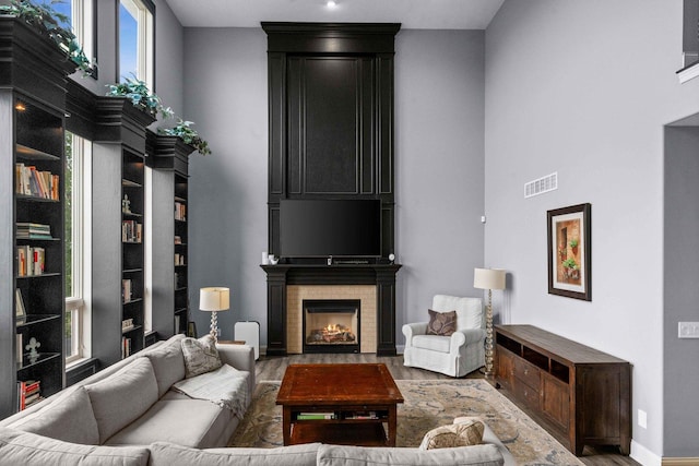 4 Emerald Crest Ct, Bloomington, IL 61705 - living area featuring wood finished floors, a towering ceiling, and a fireplace