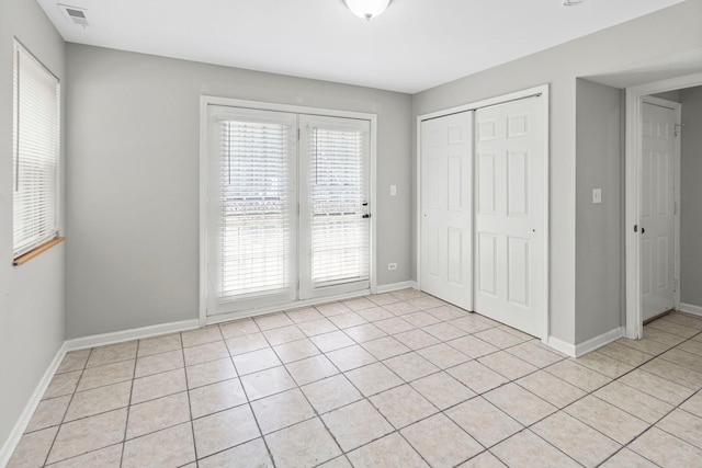 6344 S Rhodes Ave, Chicago, IL 60637 - unfurnished bedroom featuring a closet, light tile patterned floors, baseboards, and access to outside