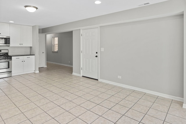 6344 S Rhodes Ave, Chicago, IL 60637 - kitchen featuring stainless steel appliances, baseboards, dark countertops, white cabinetry, and recessed lighting