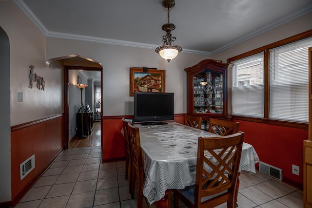 5936 S Keeler Ave, Chicago, IL 60629 - tiled dining space with arched walkways, ornamental molding, and wainscoting