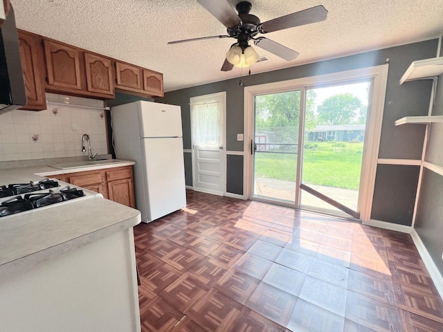 1707 Highview Ave, Mchenry, IL 60050 - kitchen with freestanding refrigerator, a sink, light countertops, brown cabinetry, and a ceiling fan