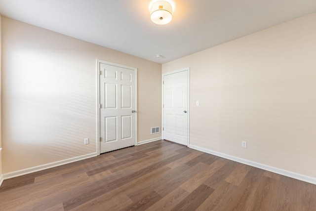 898 Fuller Ln, Belvidere, IL 61008 - unfurnished bedroom featuring baseboards and dark wood finished floors