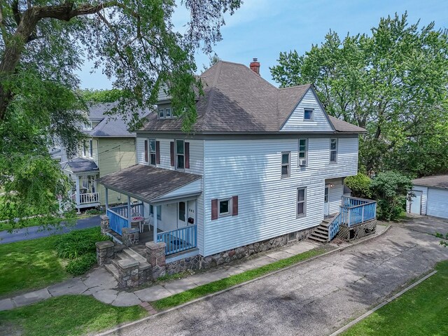 645 E Calhoun St, Woodstock, IL 60098 - view of front of house featuring a chimney, a porch, a shingled roof, a garage, and a front yard