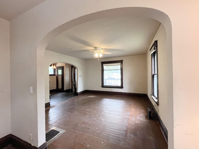 645 E Calhoun St, Woodstock, IL 60098 - unfurnished room featuring ceiling fan, arched walkways, and dark wood-type flooring
