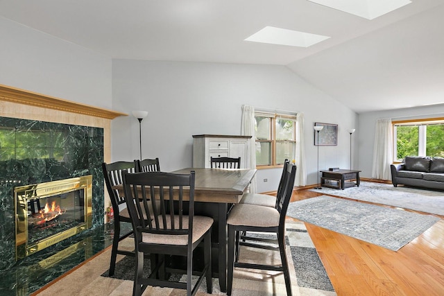 2040 Honey Locust Dr, Algonquin, IL 60102 - dining area featuring a fireplace, vaulted ceiling, a skylight, and wood finished floors
