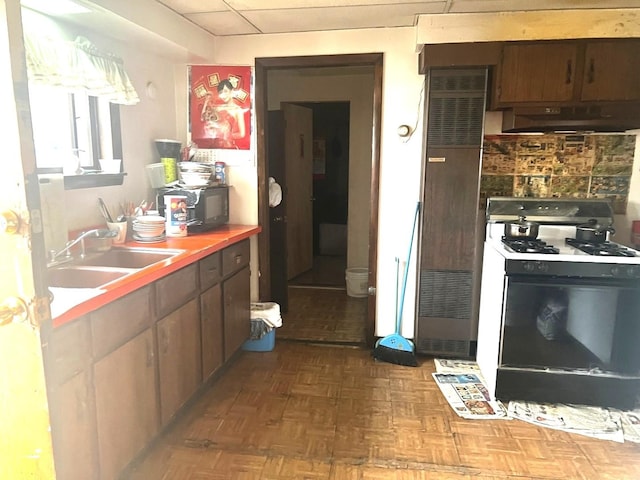256 W 23rd Pl, Chicago, IL 60616 - kitchen with white range with gas cooktop, under cabinet range hood, a sink, a heating unit, and black microwave