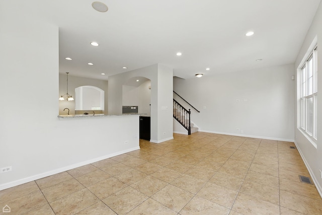652 Grosvenor Ln, Aurora, IL 60504 - unfurnished living room featuring stairs, recessed lighting, baseboards, and arched walkways