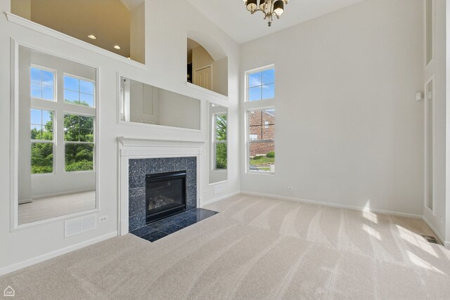 652 Grosvenor Ln, Aurora, IL 60504 - unfurnished living room with carpet floors, a high ceiling, a chandelier, a fireplace, and baseboards