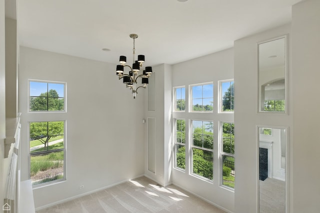 652 Grosvenor Ln, Aurora, IL 60504 - unfurnished dining area with light carpet, a chandelier, baseboards, and a high ceiling